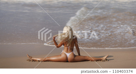 Tanned Bikini Beach Woman in Yoga Pose Doing Stretching Leg-split on Seashore Tanned Bikini Beach Woman in Yoga Pose Doing Stretching Leg-split on Seashore 110403374