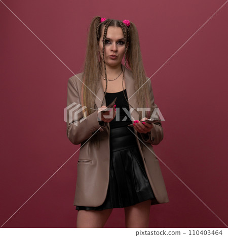 Portrait of a cheerful young woman holding money banknotes and celebrating isolated over red background 110403464