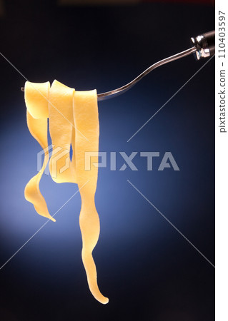 Fork with tagliatelle on a red background Fork with tagliatelle on a red background 110403597