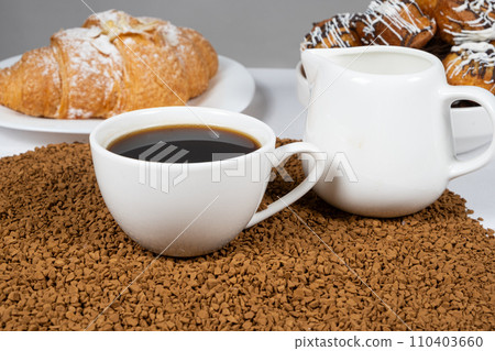 A cup of hot instant coffee on a background of freeze-dried granules 110403660