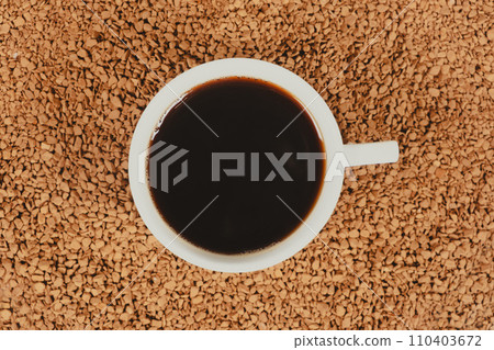 A cup of hot instant coffee on a background of freeze-dried granules 110403672