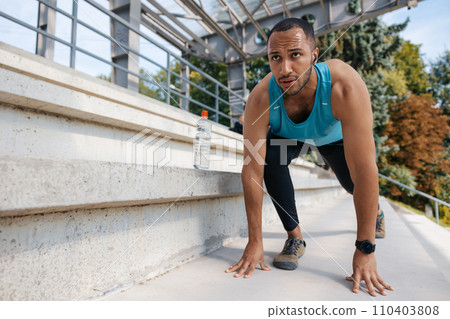 Young well-built man having a workout and looking determined Young well-built man having a workout and looking determined 110403808