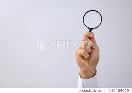 Magnifying glass in male hand on white background, space for text 110404069