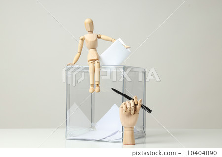 Transparent box, voting papers, wooden man and hand with pen on gray background 110404090