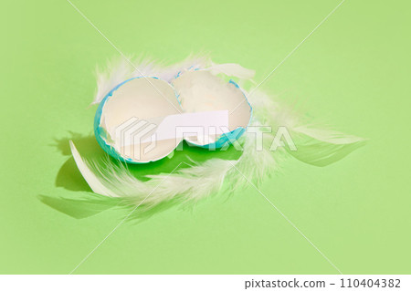 Cracked painted egg with paper inside over green background. Whishes. Ester, holiday Cracked painted egg with paper inside over green background. Whishes. Ester, holiday 110404382