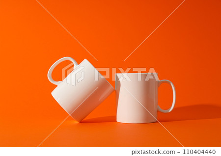 White beautiful cups on an orange background 110404440
