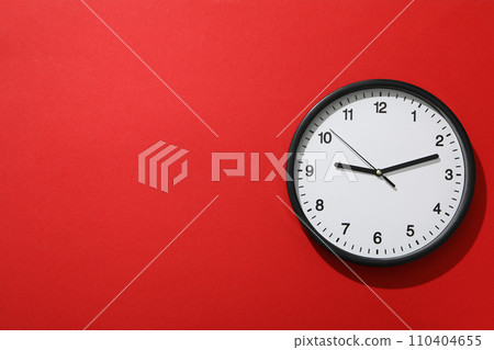 A round clock on a red background 110404655