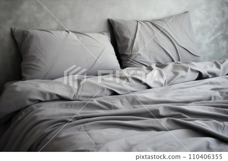 A bed with gray bed linen , a blanket and pillows A bed with gray bed linen , a blanket and pillows 110406355