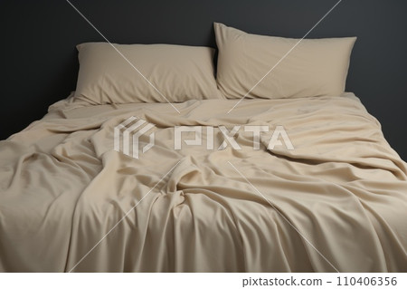 Crumpled beige bed linen with pillows and blankets 110406356