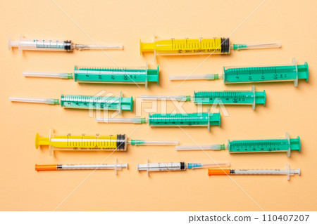 Top view of syringes and insulin syringes at orange background. Medical injection concept with copy space Top view of syringes and insulin syringes at orange background. Medical injection concept with copy space 110407207