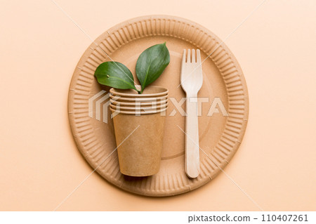 set of empty reusable disposable eco-friendly plates, cups, utensils on light white colored table background. top view. Biodegradable craft dishes. Recycling concept. Close-up 110407261