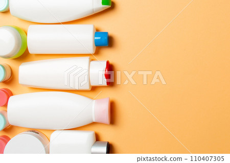 Top view of cosmetics bottles on colored background. Skin care concept with space for your design Top view of cosmetics bottles on colored background. Skin care concept with space for your design 110407305