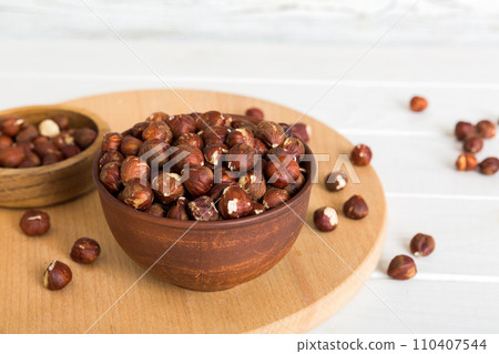 Wooden bowl full of hazelnuts on table background. Healthy eating concept. Super foods 110407544