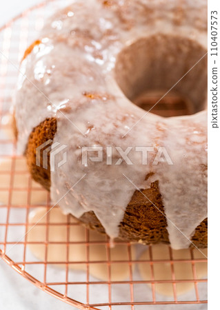 Glazing vanilla bundt cake with a white vanilla glaze. Glazing vanilla bundt cake with a white vanilla glaze. 110407573