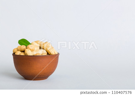 Fresh healthy peanuts in bowl on colored table background. Top view Healthy eating bertholletia concept. Super foods Fresh healthy peanuts in bowl on colored table background. Top view Healthy eating bertholletia concept. Super foods 110407576