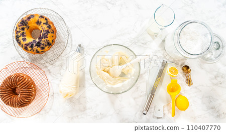 Flat lay. Skillfully combine ingredients using a hand mixer to prepare a rich, smooth cream cheese buttercream frosting, which is perfect for adorning the bundt cake. Flat lay. Skillfully combine ingredients using a hand mixer to prepare a rich, smooth cream cheese buttercream frosting, which is perfect for adorning the bundt cake. 110407770