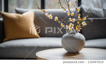 Close-up of a ceramic vase with flowers on a round coffee table against the background 110407819