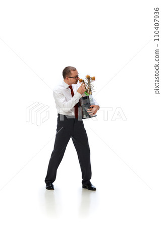 Businessman holding trash bin, sniffing dried flower bouquet isolated over white background Businessman holding trash bin, sniffing dried flower bouquet isolated over white background 110407936