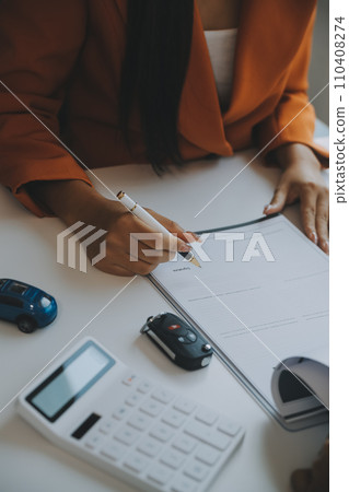 Closeup asian male people car salesman or sales manager offers to sell a car and explains and reads the terms of signing a car contract and insurance. 110408274