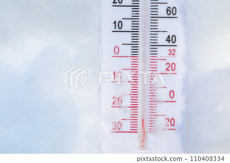 Outdoor thermometer in snow shows frigid winter temperature 110408334