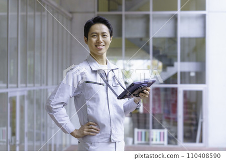 一名穿著工作服的年輕人看著平板電腦。攝影由有明教育藝術學院提供。 110408590