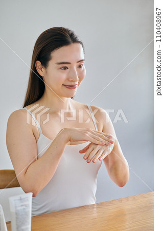 30多歲的女性塗抹護手霜並按摩雙手 110408967