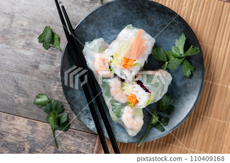 Vietnamese spring rolls with vegetables, rice noodles and prawns on wooden table Vietnamese spring rolls with vegetables, rice noodles and prawns on wooden table 110409168
