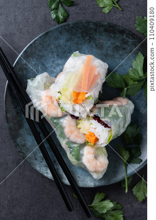 Vietnamese spring rolls with vegetables, rice noodles and prawns on black slate background 110409180