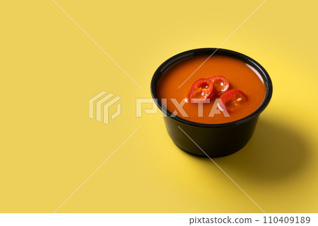 Spicy chili sauce in a bowl on yellow background 110409189