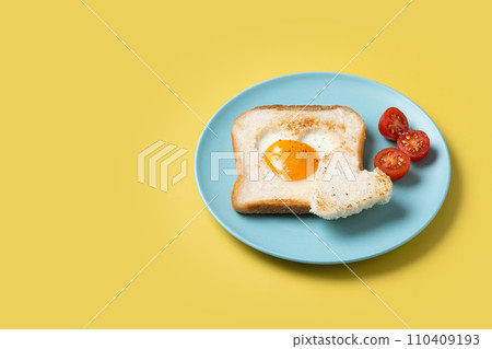 Valentine's Day breakfast with egg with tomatoes, heart shaped and toast bread on yellow background 110409193
