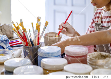 Kids making a craft of a porcelain mug from wet clay Kids making a craft of a porcelain mug from wet clay 110411054