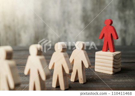 Red wooden figures stand out from the crowd of wooden figures 110411468