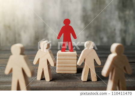 Red wooden figures stand out from the crowd of wooden figures 110411470