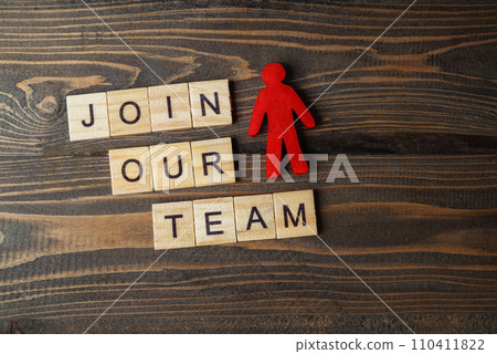 Wooden figures and wooden cubes with Join Our Team letters on a wooden table 110411822