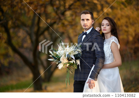 beautiful sensual bride in white wedding dress and groom standing outdoor on natural background 110413082
