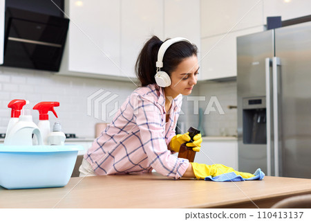 young woman cleaning and wiping wooden table with microfiber cloth. chores at home. Housekeeping young woman cleaning and wiping wooden table with microfiber cloth. chores at home. Housekeeping 110413137