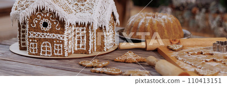 Gingerbread house on a wooden table in a Christmas loft kitchen 110413151