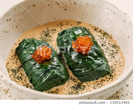 Stuffed green cabbage rolls with sauce in restaurant-style plating, served red caviar 110413461