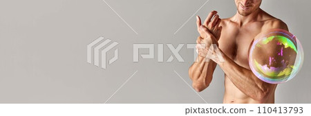 Cropped image of muscular shirtless male body, strong relief hands with soap bubble maximizing body part against grey background Cropped image of muscular shirtless male body, strong relief hands with soap bubble maximizing body part against grey background 110413793