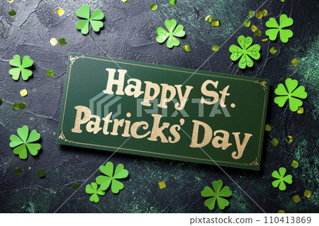 Phrase "Happy St. Patricks' Day" written on a green background with green clovers and confetti background Phrase "Happy St. Patricks' Day" written on a green background with green clovers and confetti background 110413869