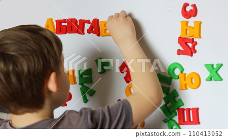 the child is playing with the letters of alphabet. Intellectual play, preschool primary education the child is playing with the letters of alphabet. Intellectual play, preschool primary education 110413952