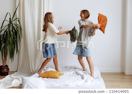 Two girls have a pillow fight Two girls have a pillow fight 110414005