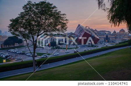 Luxurious shopping mall in Katara cultural village in Doha Qatar exterior sunset shot showing the entrance with people and cars in the street Luxurious shopping mall in Katara cultural village in Doha Qatar exterior sunset shot showing the entrance with people and cars in the street 110414741