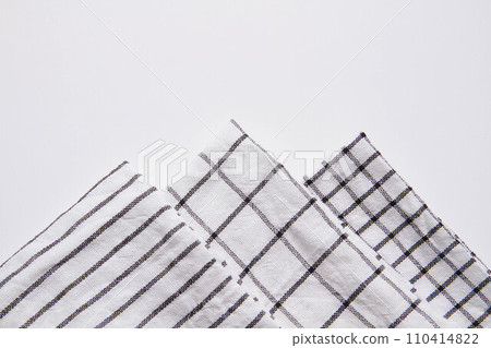 Plaid material. Towel on the table. Wrinkled fabric with stripes. Plaid material. Towel on the table. Wrinkled fabric with stripes. 110414822
