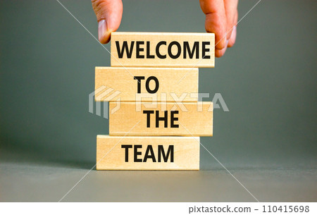 Welcome to the team symbol. Concept words Welcome to the team on wooden block. Beautiful white table white background. Businessman hand. Business, motivational and welcome to the team concept. 110415698