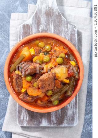 Homemade beef stew with potato, green beans, carrot, peas and corn, in ceramic bowl, vertical, top Homemade beef stew with potato, green beans, carrot, peas and corn, in ceramic bowl, vertical, top 110416881