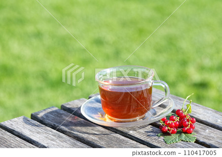 A cup of tea on the green grass background A cup of tea on the green grass background 110417005
