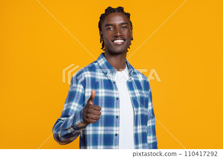 Cheerful young black man in plaid shirt giving thumb up at camera 110417292