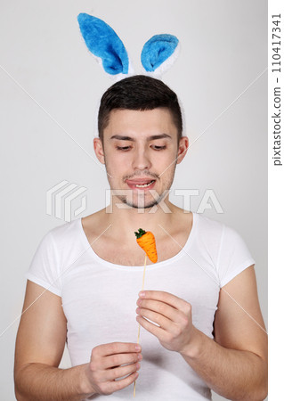 Handsome young man in rabbit ears on a white background. Easter concept 110417341