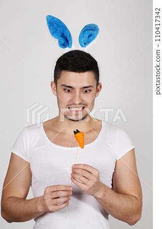 Handsome young man in rabbit ears on a white background. Easter concept 110417342
